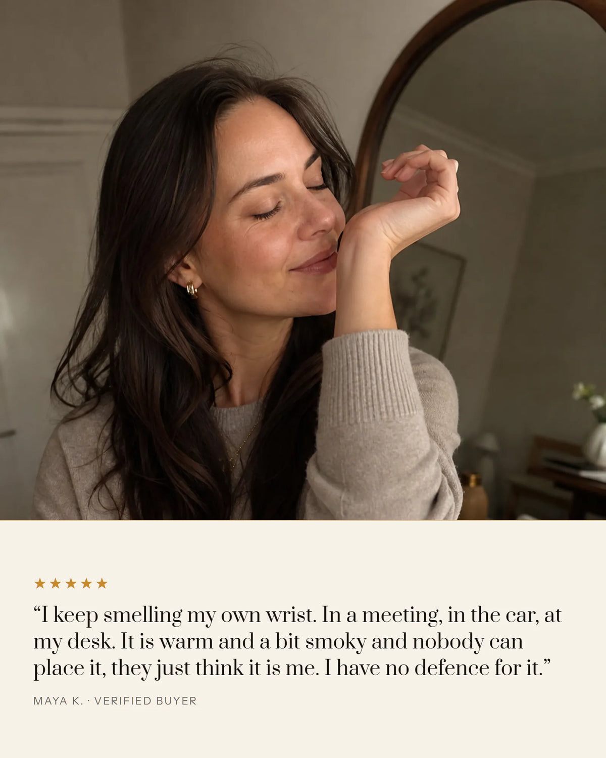 Woman smelling Désir on her own wrist, five star review: warm and a bit smoky, and nobody can place it