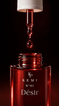 Désir extrait poured — dropper macro over the ruby bottle